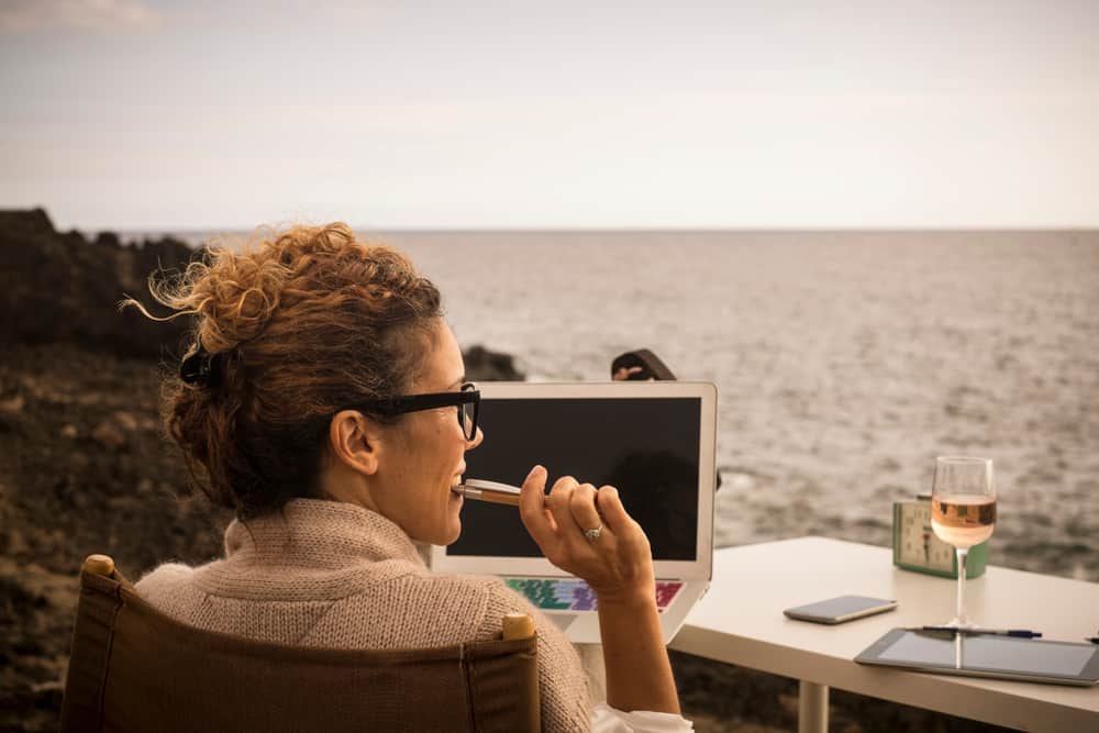 A writer with her laptop by the sea.