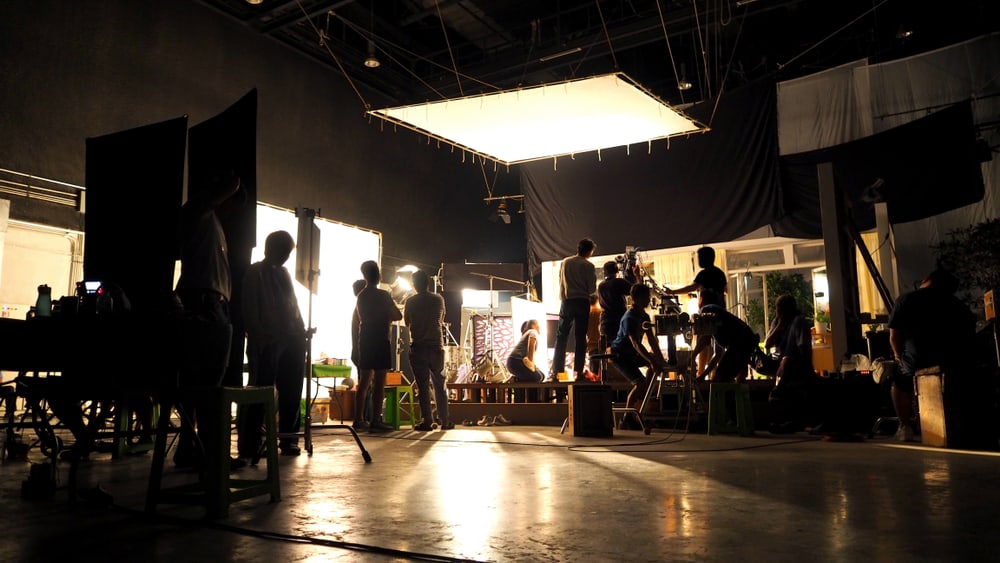 This is a view of behind the camera at a film shooting showcasing multiple film crews working behind the scenes.