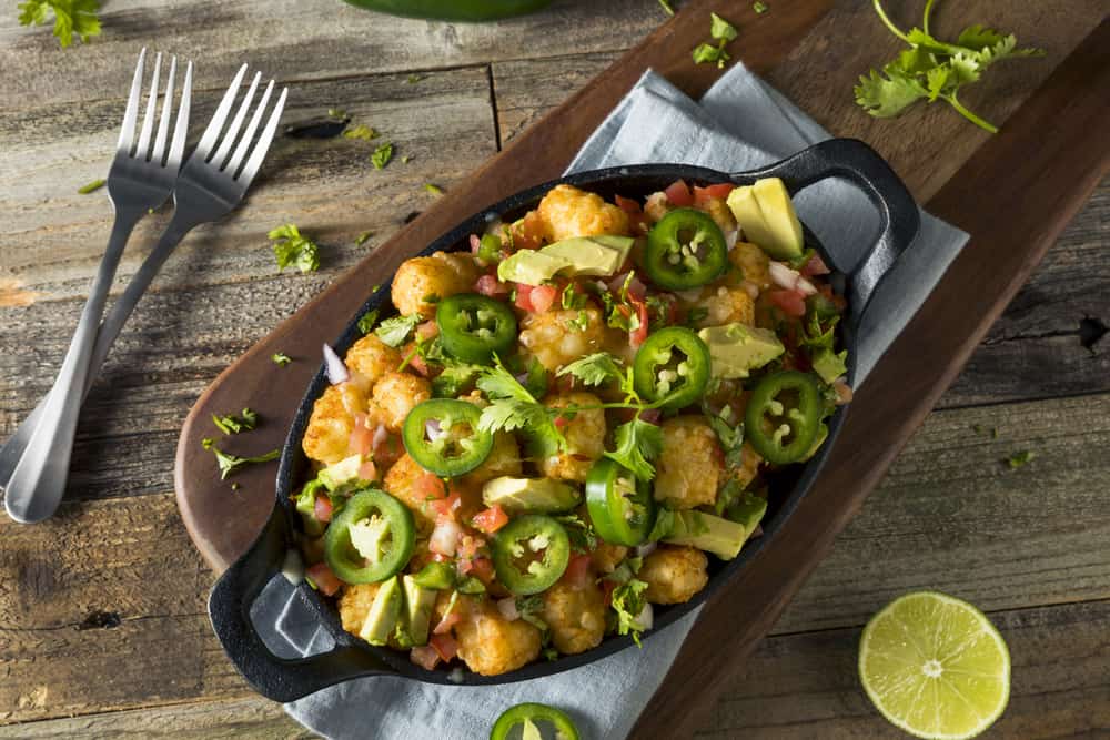 Mexican tater tot nachos with cheese, cilantro and jalapeño.