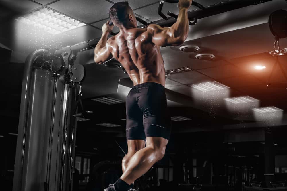 This is a man doing pull-ups at the gym.