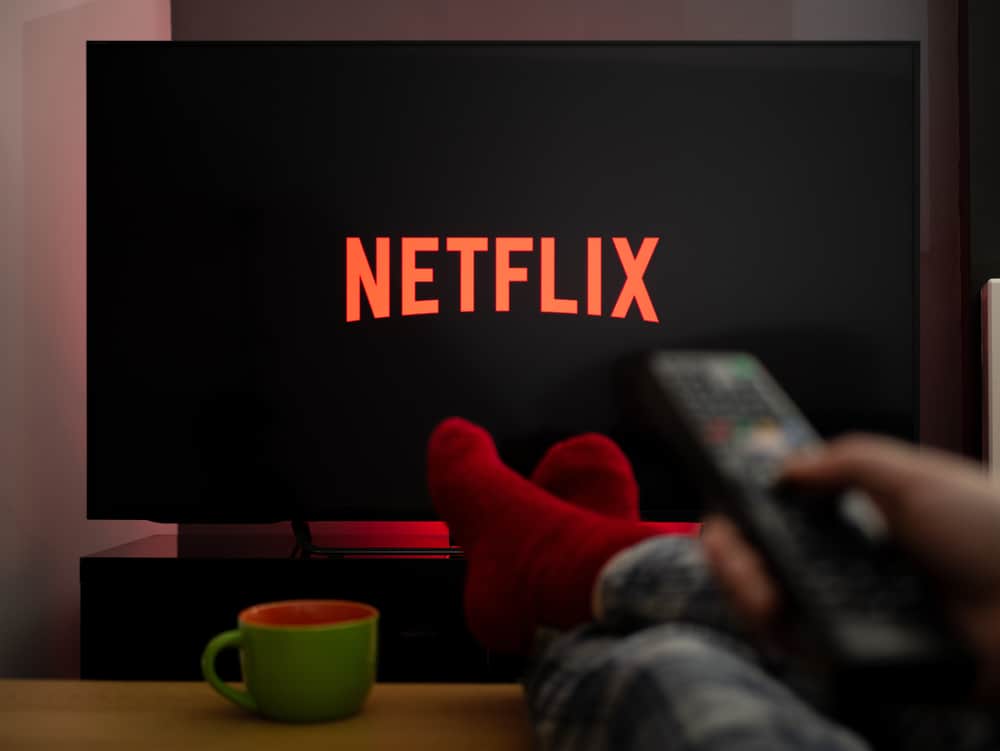 Man with his feet up over the table watching Netflix.