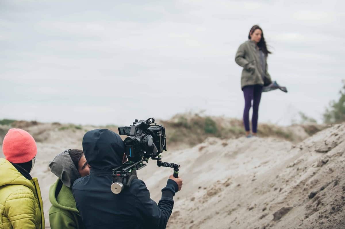 Actress and production team filming outdoors.