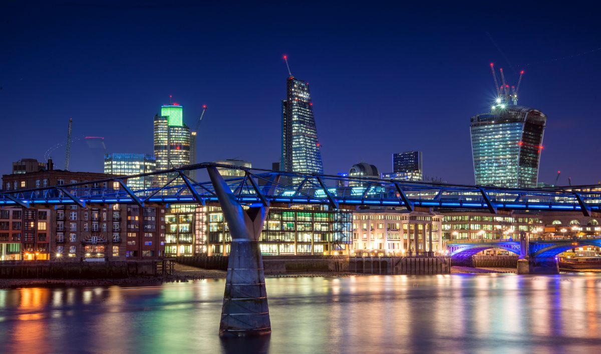 A landscape photo of a city and bridge at night.